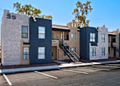 Thumbnail 2 of 21 - A row of modern townhouses with a clear blue sky above.
