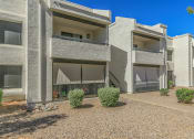 Thumbnail 7 of 19 - an exterior view of two apartment buildings with a gravel courtyard at Tides on Southern, Mesa Arizona