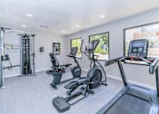 Thumbnail 22 of 28 - the fitness center with a treadmill, elliptical, and plank flooring with large windows that overlook the patio at Tides on McDowell, Arizona