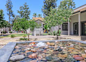 Thumbnail 15 of 28 - Leasing center entry with a river rock water feature in front at Tides on McDowell, Arizona