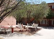 Thumbnail 4 of 5 - A courtyard with a table and chairs surrounded by trees at Ambassador West Apartments, Phoenix, AZ, 85003