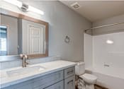 Thumbnail 16 of 16 - A bathroom with a white toilet, sink, and bathtub.