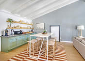 Thumbnail 17 of 27 - a dining area with a white table and chairs and a kitchen with blue cabinets