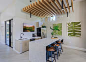 Thumbnail 16 of 23 - a kitchen with a marble counter top and a bar with stools