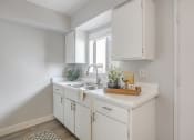 Thumbnail 4 of 24 - a kitchen with white cabinets and a sink and a window