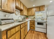 Thumbnail 2 of 13 - a kitchen with white appliances and wooden cabinets at Connect on Northern, Arizona