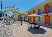Thumbnail 14 of 16 - A sunny day at the colorful courtyard with a table and chairs.