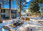 Thumbnail 26 of 28 - A snow-covered ground with a picnic table in the middle of a street.