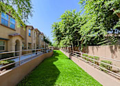 Thumbnail 24 of 29 - A row of houses with a green lawn in between.
