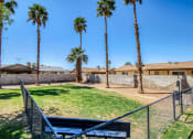 Thumbnail 22 of 24 - a yard with a bench and a fence with palm trees