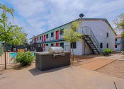 Thumbnail 12 of 14 - a backyard with a grill and a pool in front of a white building with red and green