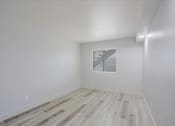 Thumbnail 8 of 14 - a bedroom with hardwood floors and white walls