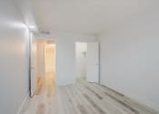 Thumbnail 8 of 12 - a bedroom with hardwood floors and white walls