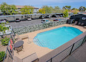 Thumbnail 18 of 20 - A small pool with a table and chairs.