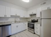 Thumbnail 2 of 14 - a kitchen with white cabinets and stainless steel appliances