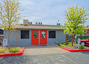 Thumbnail 20 of 20 - A building with a red door and a parking sign in front.
