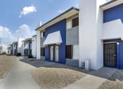 Thumbnail 14 of 24 - a row of blue and white apartment buildings with a sidewalk