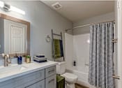 Thumbnail 9 of 16 - A bathroom with a toilet, sink, and shower.