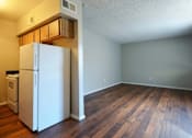 Thumbnail 6 of 19 - A white refrigerator is in a room with wood floors at Gilbert Square Apartments, Mesa