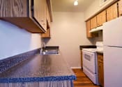 Thumbnail 8 of 19 - A kitchen with a white refrigerator and a white oven at Gilbert Square Apartments, Mesa, AZ
