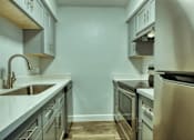 Thumbnail 11 of 19 - A kitchen with a sink, stove, and oven at Gilbert Square Apartments, Arizona