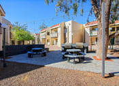 Thumbnail 28 of 32 - a courtyard with picnic tables and benches and buildings in the background