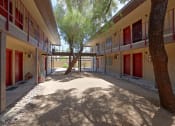 Thumbnail 2 of 13 - a courtyard with trees and red doors