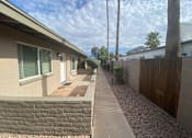 Thumbnail 2 of 2 - A residential area with a house, a fence, and a tree.