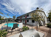 Thumbnail 13 of 20 - A large building with a pool in front of it.