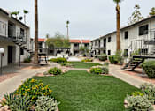 Thumbnail 14 of 18 - A courtyard with a lawn and a building in the background.