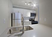Thumbnail 3 of 24 - a kitchen and dining room with stainless steel appliances and a table and chairs