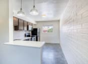 Thumbnail 5 of 10 - a kitchen with a white counter top and a white brick wall