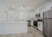 Thumbnail 2 of 14 - an empty kitchen with white cabinets and stainless steel appliances