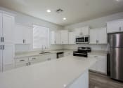Thumbnail 3 of 14 - a kitchen with white cabinets and stainless steel appliances