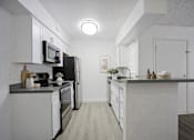 Thumbnail 9 of 44 - A kitchen with white cabinets and appliances.