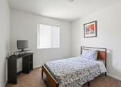 Thumbnail 7 of 15 - a bedroom with a bed and a desk