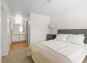 Thumbnail 8 of 15 - a bedroom with a bed and a nightstand