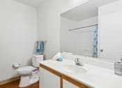 Thumbnail 9 of 15 - a bathroom with a sink toilet and mirror
