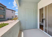 Thumbnail 11 of 15 - a patio with a blue door and a bathroom in the background