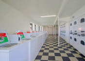 Thumbnail 6 of 21 - a row of washing machines in a laundromat