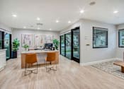 Thumbnail 15 of 26 - A modern home office with a desk, chairs, and a view of the backyard.