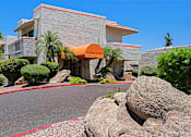 Thumbnail 78 of 94 - A large rock sits in front of a building with a sign that says "Leasing Office".
