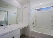 Thumbnail 4 of 14 - a bathroom with a tub and a sink and a mirror