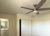 Thumbnail 8 of 8 - a bedroom with a closet and a ceiling fan