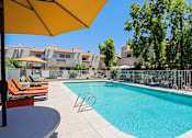 Thumbnail 69 of 94 - A pool surrounded by chairs and umbrellas.