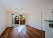 Thumbnail 4 of 21 - A room with a ceiling fan and wooden floors.