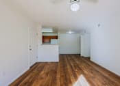Thumbnail 3 of 21 - A room with wooden floors and white walls.