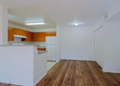 Thumbnail 7 of 21 - A kitchen with wooden floors and white walls.
