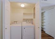 Thumbnail 6 of 21 - A small laundry room with a washer and dryer.