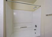 Thumbnail 11 of 21 - A white bathroom with a shower stall and a towel bar.